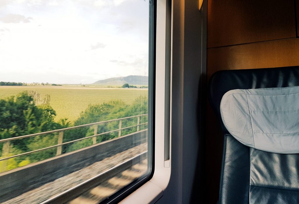 Foto di un paesaggio scattata dal finestrino di un treno in movimento.