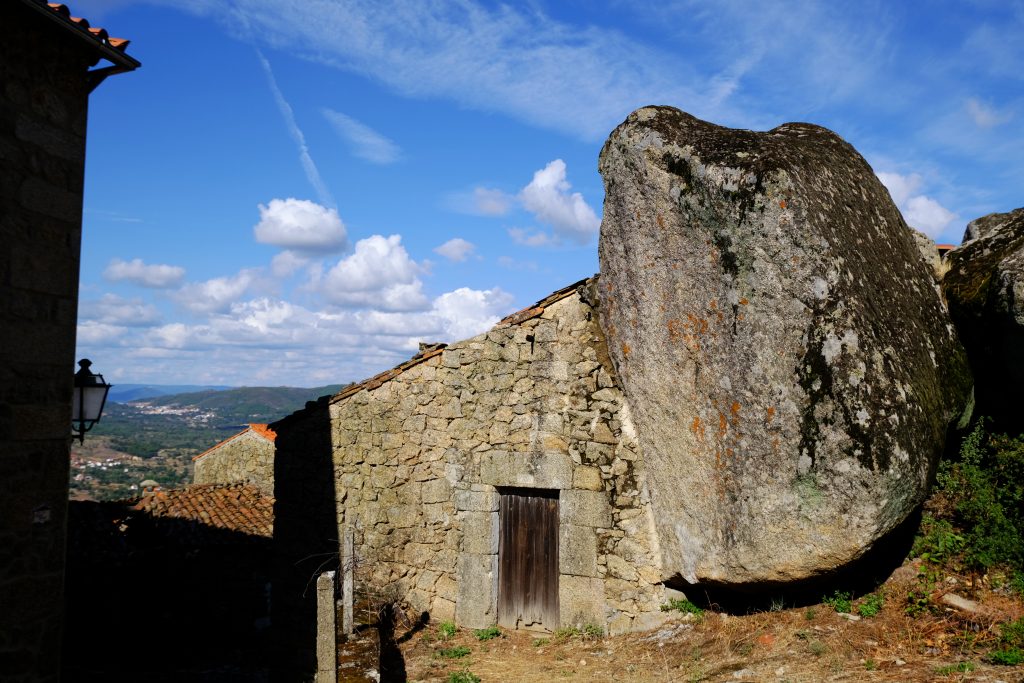 Foto di una casa costruita vicino a una roccia a Monsanto, Portogallo.
